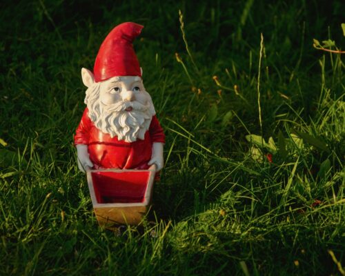 Garden,Gnome,Ornament,Figurine,In,Red,With,Wheelbarrow.,Gardener,Working